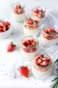 Easy panna cotta italian dessert in glass jars with strawberries.